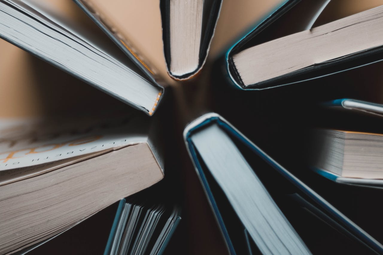 Top-down view of open books arranged in a circle showing spines and pages.